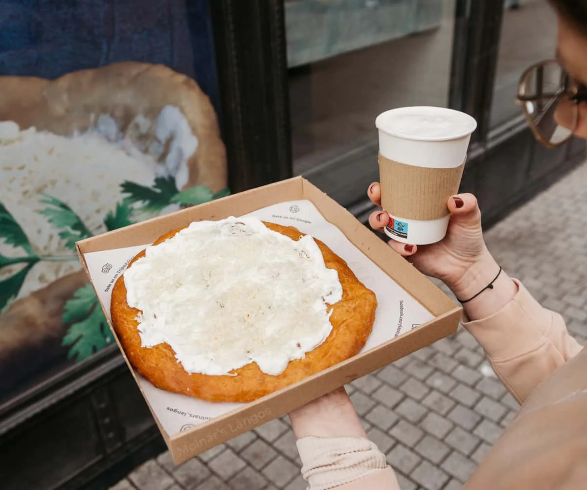 Takeaway sour cream and cheese lángos with coffee